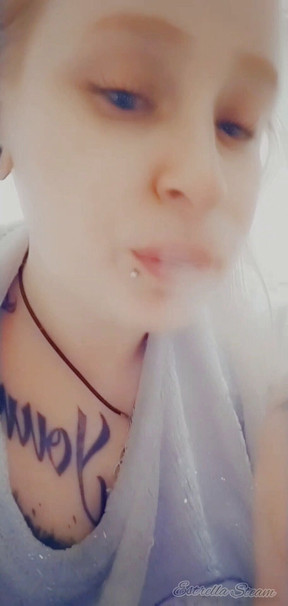 Girl with piercings smokes a cigarette