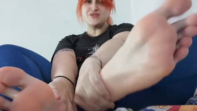 Cute redhead massaging her feet after a workout