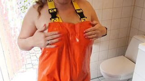 Lusty mom dressing up into rainpants - oiling big boobies